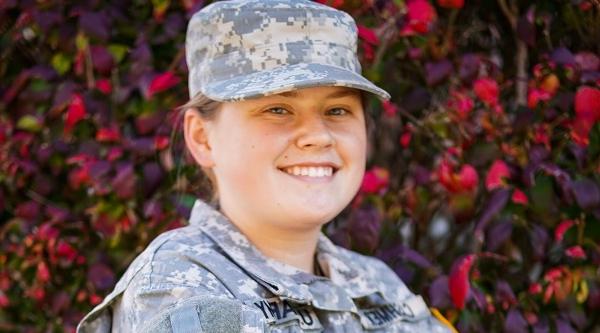 military student in uniform smiling on campus